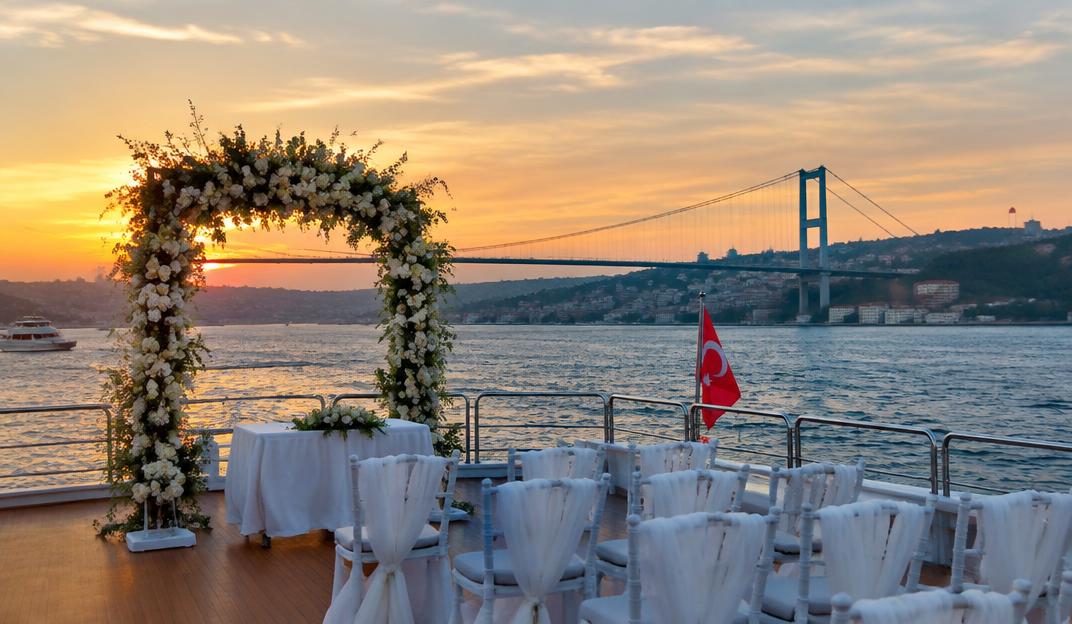Wedding setup with floral arch on a Bosphorus yacht at sunset